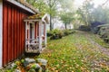 Red cottage with a porch in a rural landscape in the fall Royalty Free Stock Photo