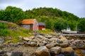 Red cottage with summer flower fields by the sea Is home to fishermen in the Lofoten Islands Royalty Free Stock Photo