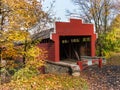 Red covered bridge surrounded by fall foliage Royalty Free Stock Photo