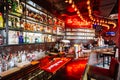 Red and cozy bar counter interior decorated with light bulbs, alcohol, liquors and spirits