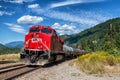 A red CP freight train is contrasted against a vivid blue sky