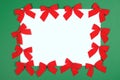 Red Cristmas bows on green background