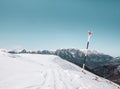 Red cross hiking trail mark on a pole with huge mountain in the background. Winter landscape in Bucegi Mountains Romania Royalty Free Stock Photo