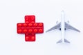 Red cross from packs of pills with an airplane model on a white background. danger coronavirus
