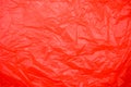 Red crumpled plastic surface with a shiny texture and a myriad of folds and creases Royalty Free Stock Photo
