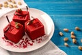 Red cube-shaped cakes with pistachio biscuit, chocolate souffle, raspberry confit and nut crumbs Royalty Free Stock Photo