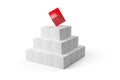 Red cube on top of pyramid of white cubes over white background - software module, teamwork or standing out from the crowd