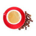 Red cup of aromatic coffee, saucer and beans isolated on white, top view Royalty Free Stock Photo
