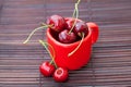 Red cup and a cherry on a bamboo mat Royalty Free Stock Photo