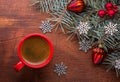 Red cup of coffee and fir branch with Christmas decorations on old wooden table Royalty Free Stock Photo