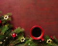 Red cup of coffee and fir branch with Christmas decorations on the wooden board painted in dark-red with copy space for text. Flat Royalty Free Stock Photo