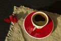 Red cup of coffee with flower on linen cloth