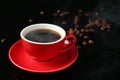 Red cup with coffee and roasted beans on black background, closeup. Space for text Royalty Free Stock Photo