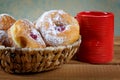 Red cup and fruitcakes in plates on a table