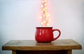 Red cup and heart shaped bokeh over it on white background. Valentine`s Day concept Royalty Free Stock Photo