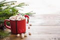 Red cup of hot chocolate with marshmallow on windowsill. Weekend concept. Home style. Christmas time. Royalty Free Stock Photo