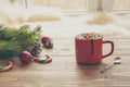 Red cup of hot chocolate with marshmallow on windowsill. Weekend concept. Home style. Christmas time, morning. Royalty Free Stock Photo