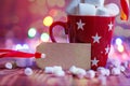 Red cup of hot cocoa with marshmallows and candy canes a colorful bokeh background with beautiful Christmas lights with blank for Royalty Free Stock Photo