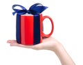 Red cup mug with blue ribbon bow gift in hand Royalty Free Stock Photo