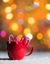 Red cup, red mug with candy canes in snow with bokeh in the background Royalty Free Stock Photo