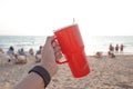 Red cup in sand at sunset. Summer beach party concept with copy space. Royalty Free Stock Photo