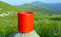 Red cup on stone in mountains camp