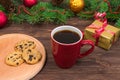 Red cup with tea, coffee with cookies and marshmallows on a wooden table against the background of a New Year tree with Royalty Free Stock Photo