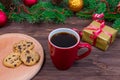 Red cup with tea, coffee with cookies and marshmallows on a wooden table against the background of a New Year tree with Royalty Free Stock Photo