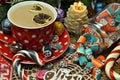 Red cup of tea with dessert, candy and candle on festive table Royalty Free Stock Photo