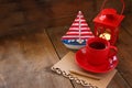 Red cup of tea and letter paper next to vintage decorative boat and lantern on wooden old table. retro filtered image Royalty Free Stock Photo