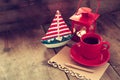 Red cup of tea and letter paper next to vintage decorative boat and lantern on wooden old table. retro filtered image Royalty Free Stock Photo