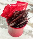 red cup on wooden table with various sugar sachet for coffee