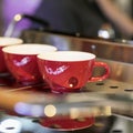 Red cups on the stand of the coffee machine, bar. Vintage dark tone, coffee time, square background. Coffee culture Royalty Free Stock Photo