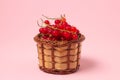 Red currant in a basket on a pink background. Fresh ripe red currant. Royalty Free Stock Photo