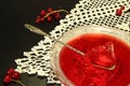 Red currant jelly in glass bowl against black background