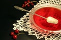 Red currant jelly in glass bowl against black background