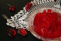 Red currant jelly in glass bowl against black background