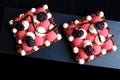 Red currant mousse and blackberry puff pastry desserts with whipped ganache and chocolate spiral decorations, top view