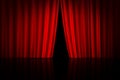 Red curtain on theater or cinema stage slightly open