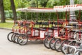 Red cyclo velomobiles with a canopy for the whole family. Parked rental tourist trike vehicles. Ecological transport for walking