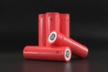 5 red cylindrical batteries on a black background. Storage battery or secondary cell. Rechargeable batteries for