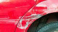 Red damaged car in crash accident with scratched paint and dented metal body Royalty Free Stock Photo