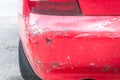 Red damaged car in crash accident with scratched paint and dented rear bumper metal body Royalty Free Stock Photo