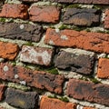 Red and dark brown bricks arranged in a diagonal pattern with visible signs of agin Royalty Free Stock Photo