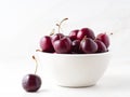 red dark sweet cherries in white bowl on stone white table, side view. Royalty Free Stock Photo