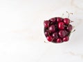 red dark sweet cherries in white bowl on stone white table, top view, copy space Royalty Free Stock Photo