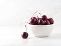 red dark sweet cherries in white bowl on stone white table, side view, copy space Royalty Free Stock Photo