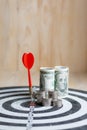 Red dart arrow hit the center target of dartboard and money coin Royalty Free Stock Photo