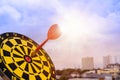 Red dart arrow hit in the target center of dartboard with sky background Royalty Free Stock Photo