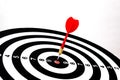 Red dart arrow hitting in the target center of dartboard Royalty Free Stock Photo